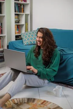 Non-binary person, working from home with their laptop with a happy face Stock Photos
