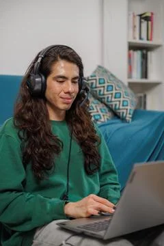 Non-binary person working from home with their laptop and headphones Stock Photos