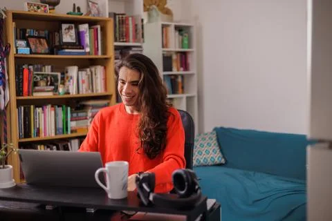 Non-binary person working from home with books in blurry background Stock Photos