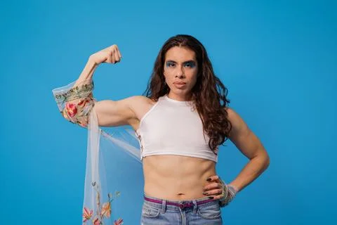 Non-binary styled person showing the strength of their arm as a symbol of pow Stock Photos