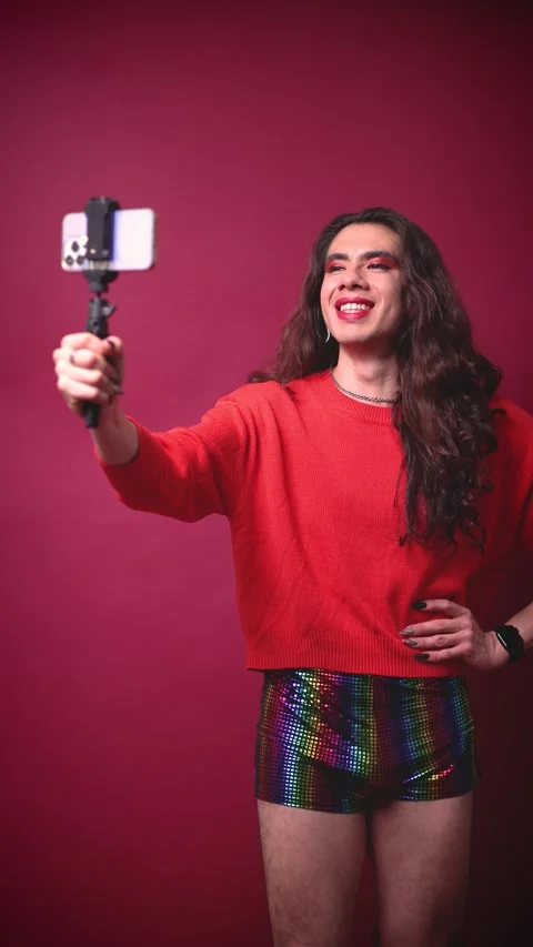 Non-binary stylish person creating content with their cell phone like an Stock Footage 309138474