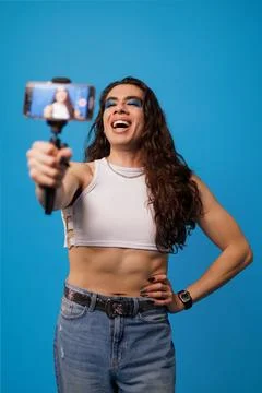 Non-binary stylish person creating content with their cell phone like an in.. Stock Photos