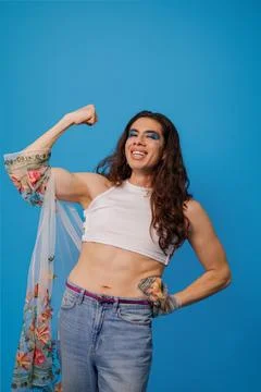 Non-binary stylish person smiling showing the strength of their arm as a sy.. Stock Photos