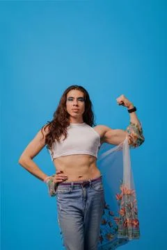 Non-binary stylish person smiling showing the strength of their arm as a sy.. Stock Photos