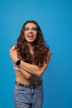 Non-binary stylish person smiling very happy hugging themselves as a sign of  Stock Photos
