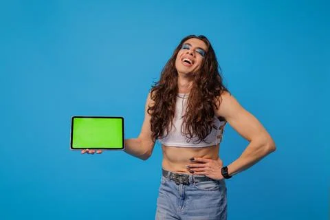 Non-binary stylish person smiling with tablet and green screen for animation Stock Photos
