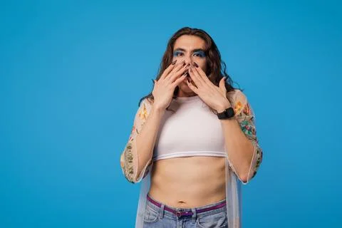 Non-binary stylish person with surprised pose and lots of impression on blu.. Stock Photos
