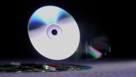 NON DESCRIPT MUSIC CD'S FALL INTO FRAME.  4K SLOW MOTION AT 60 FPS. Video stock 115729866