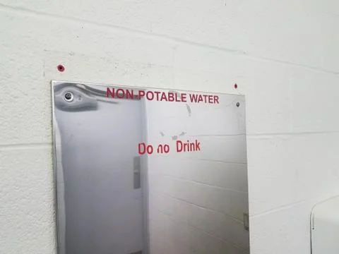 Non-potable water do not drink sign on bathroom mirror Stock Photos