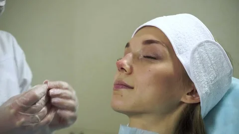 Non-surgical correction of shape of a nose. A young girl during a procedure. HD Stock Footage 71062441