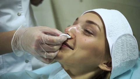 Non-surgical correction of shape of a nose. A young girl during a procedure. HD Stock-Footage 71062756