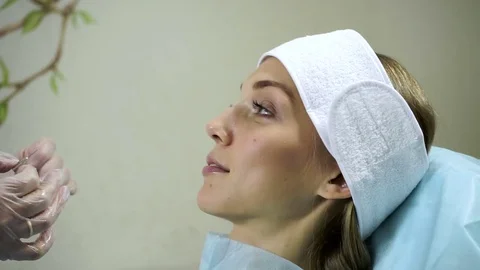 Non-surgical correction of shape of a nose. A young girl during a procedure. HD Stock-Footage 71062853