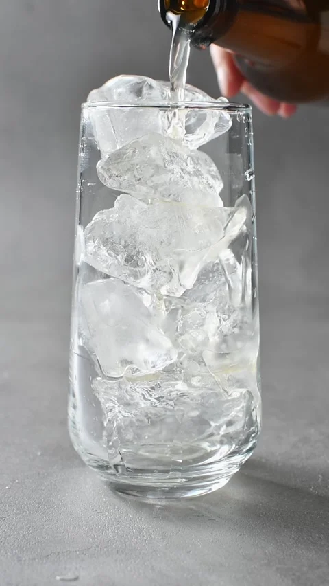 Nonalcoholic apple cider pours over ice in glass during preparation of Stock Footage 345487067