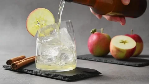 Nonalcoholic apple cider pours over ice to start preparing iced apple cider cold Stock Footage 345556781