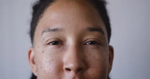 Nonbinary adult opening eyes slowly in studio, reacting to soft light and Stock Footage 345820193
