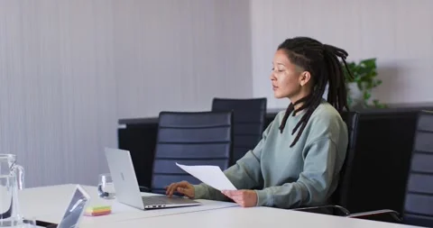 Nonbinary African-American in teal top hearing speaker, typing notes from docs Видео 345820658