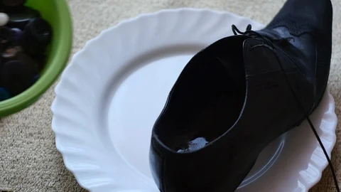 Nonsence concept - boot and buttons in plate for food Stock Footage 88242632