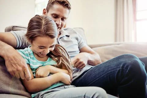 Nonstop giggles. a father and his little daughter bonding together at home. Stock Photos