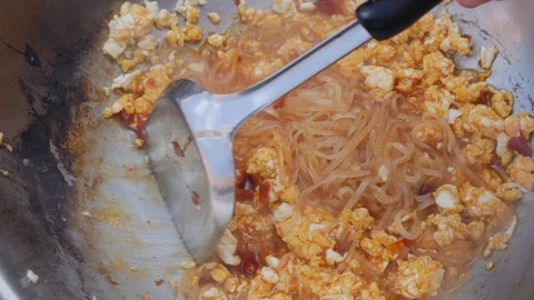 Noodles and egg fried in a wok. Step by step cooking pad thai. Thai cuisine Stock Footage 106925888