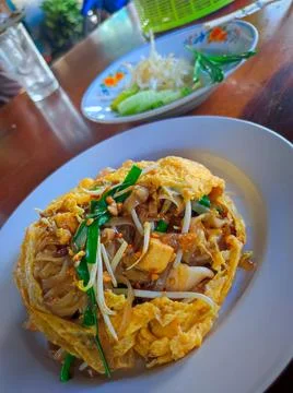 Noodles wrapped in egg with vegetables served in a local restaurant. Thaifood Stock Photos