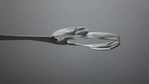 A noose hangs from a tie against a gray background.Concept of business failure Stock Footage 320297693