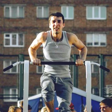 Norilsk, Russia - August, 28, 2016: male runner doing pull ups on the horizon Stock Photos