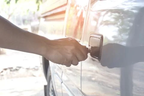 Normal Car key in men hand opening his car 库存照片