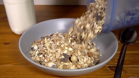 Normal speed and slow motion –  Muesli cereal pouring into a bowl. Stock-Footage 104697902