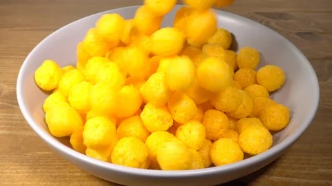 Normal speed and slow motion – Cheese balls snack falling into a bowl. Video stock 105909535
