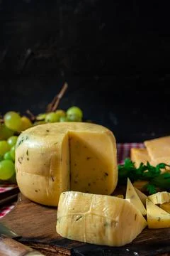 A normal view of a delicious small p ece spiced cheese on a board next to a s Stock Photos
