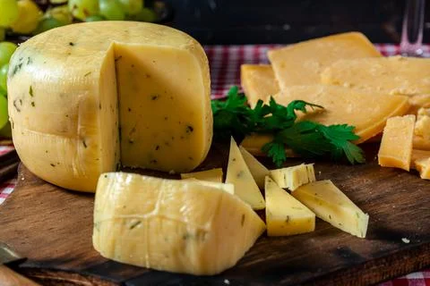 A normal view of a delicious small piece spiced cheese on a board next to a s Stock Photos