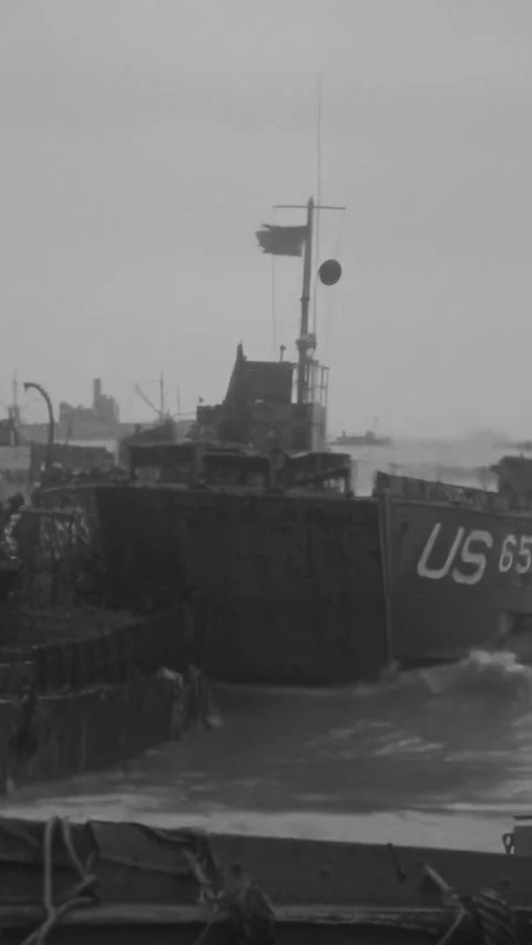 NORMANDY - 1944 - Debris surrounds British landing crafts along sinking piers Stock Footage 340298945