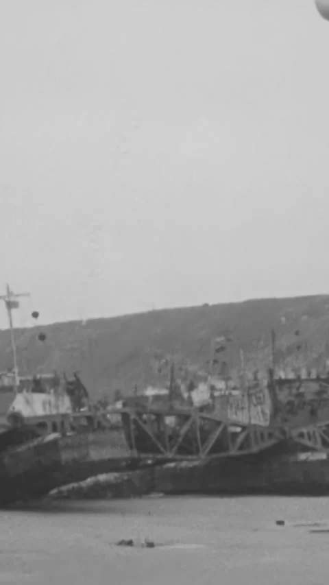 NORMANDY - 1944 - Offshore winds blow the wreckage of invasion bridges assembled Stock Footage 340298909