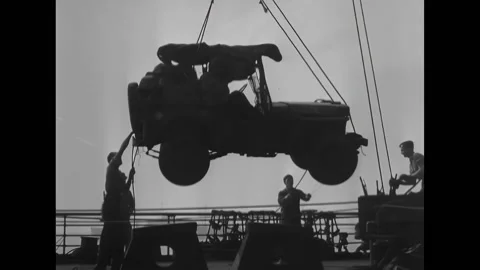 NORMANDY - 1944 - Troops lower a jeep, an engine, and other supplies from a ship Stock Footage 312791710