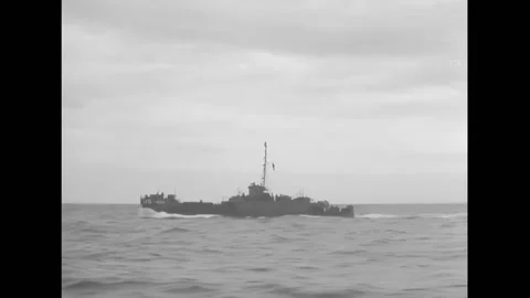 NORMANDY - 1944 - A US battleship sails, and a sailor reads a telegram while on Stock Footage 312792001