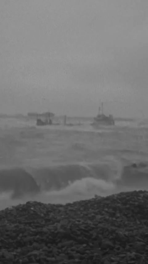 NORMANDY - 1944 - Waves wash up on Omaha Beach as US Army soldiers look out Stock Footage 340298973