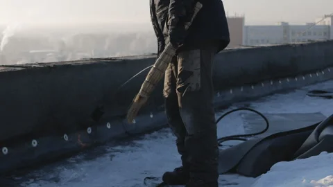 North, Arctic. A worker warms the parapet on the roof with a fire using a 動画素材 123723253