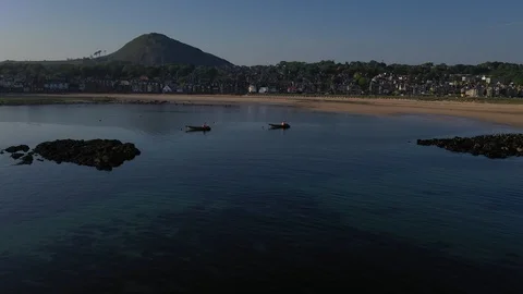 North Berwick beach panoramic, with hill in background and fast boats moored Stock Footage 108569253