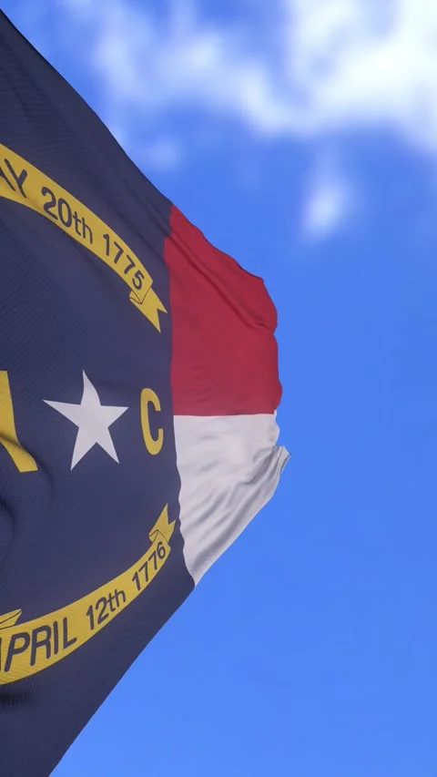 North Carolina State Flag Waving Against Bright Blue Sky Background Stock Footage 330774507