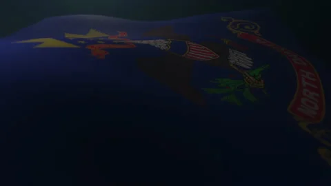 North Dakota Flag waving in a dark atmospheric environment in slow motion. Stock Footage 132811384