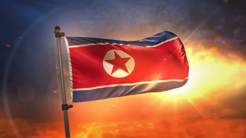 North Korea Flag Backlit At Beautiful Sunrise Loop Slow Motion 4K Stock Footage 76539842
