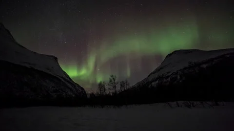 Northern light (aurora borealis) over a narrow snowy mountain passage Stock Footage 59086486
