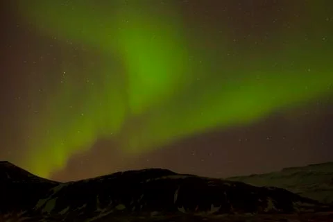 Northern lights with snowy mountains in the foreground Stock Photos