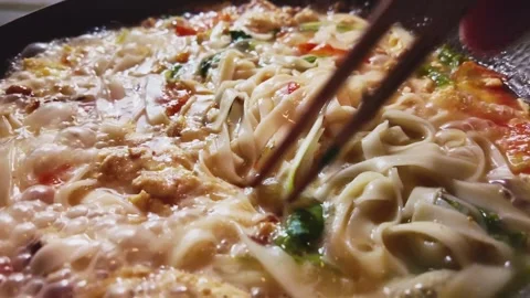 Northern Style Tomato Egg Noodle Soup in an Iron Wok Stock Footage 346300542