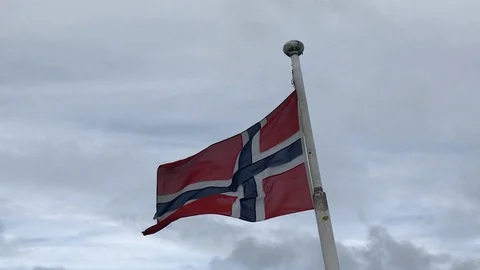 A Norwegian flag waving in the wind attached to a white pole in a cloudy day. Stock-Footage 128004517