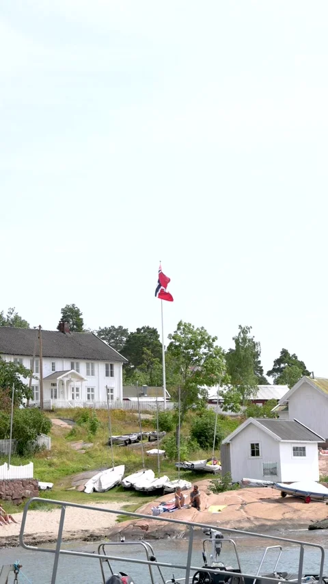 Norwegian flag in the wind by the sea vertical Stock Footage 201684009