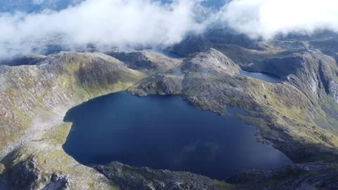 Norwegian mountain lake pull back drone shot Stock Footage 219785885