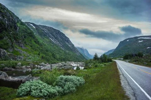 Norwegian  river  and road with dramatic sky at sunset Stock Photos