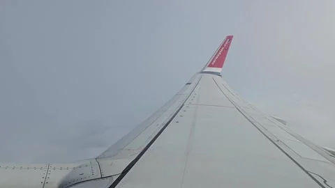 Norwegian wing flexing through clouds in light turbulence Stock Footage 345206438