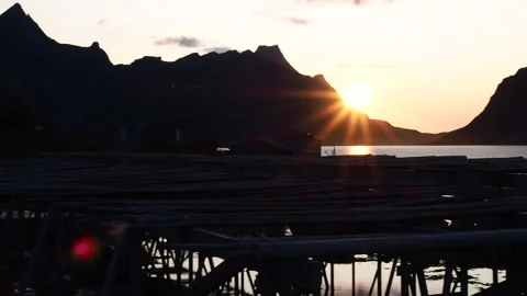 Norwegian wooden frames to dry cod during sunset in Reine; Lofoten, Norway Stock Footage 179959049